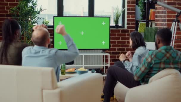 テレビのグリーンスクリーンでサッカーの試合を観戦するサッカーファンは 隔離されたコピースペースでスポーツゲームのトーナメントを楽しんでいます 空白のモックアップテンプレートとテレビの背景を見る — ストック動画