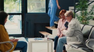 Asyalı bir hastayla sağlık kontrolünde hipertansiyonu tonometreyle kontrol eden yaşlı bir doktor. Yüksek ya da düşük nabız basıncı ölçmek ve kardiyoloji muayenesi yapmak, kardiyak muayene.