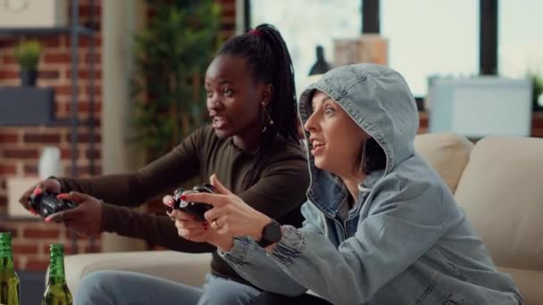 多种族的女性团队在电视控制台上玩电子游戏 在游戏比赛中玩乐 兴高采烈的人一起用控制器来挑战挑战 手持射击 — 图库视频影像