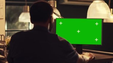 Başarılı bir ofis çalışanı iş yerindeki krom anahtar görüntüsüne bakarak bilgisayarı yeşil ekran ile analiz ediyor. İzole edilmiş model şablonu ve boş telif alanı arkaplanı, pc masaüstü ile çalışmak.