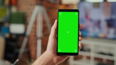 Ofis çalışanı cep telefonunda yeşil ekran şablonuyla çalışıyor. Akıllı telefon ve krom anahtar ekranı kullanıyor. İzole edilmiş fotokopi alanına bakıyorum. Kapat..