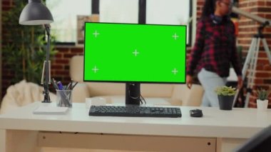 Boş ofis masası, yeşil ekran ekranlı bilgisayar oturma odasındaki çalışma odasında serbest çalışırdı. Ekranda izole edilmiş krom anahtarı ve boş kopya alanı göster.