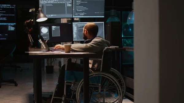 App developer with physical disability working on IT software coding, using source code and big data. Programmer wheelchair user with impairment developing new user interface.