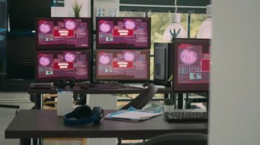 Boş ofis, bilgisayar monitörleri sistem hatası gösteriyor ve güvenlik ihlali uyarısı gösteriyor. Kritik hata iletisi yanıp sönen ekranlar, hacklenen sunucu.