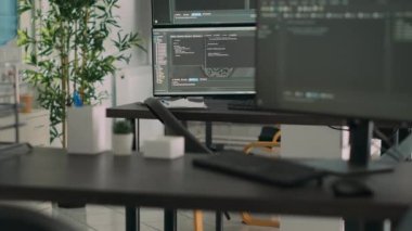 Sunucu kodu ve programlama dilini gösteren, yazılım geliştirme bürosunda derleyen birden fazla monitörü olan boş bir masa. Sistem bulut hesaplama çevrimiçi veritabanı algoritmaları.