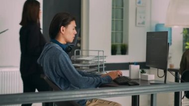 Bilgisayarda sunucu veritabanı kullanarak terminal penceresinde Html kodunu analiz eden Asyalı bilişim mühendisleri ekibi. Programlama dili ve bulut hesaplama arayüzü hakkında konuşan kodcular.