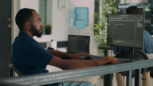 アフリカ系アメリカ人のコーダーは 端末ウィンドウでHtmlコードとスクリプトとアプリインターフェースを開発し 言語をプログラミングする 開発機関におけるデータベース情報を用いたシステムエンジニア — ストック動画