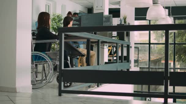 具有慢性残疾的程序员在计算机上输入源代码 与云计算终端窗口一起工作 公司办公室的轮椅写作Ai算法的软件工程师 三脚架射击 — 图库视频影像