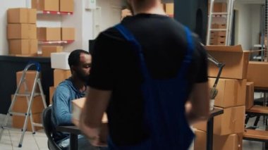 Girişimci takımı malları karton kutulara koyar, kargo ve teslimat için paketler hazırlar. Depoda mal yönetimi, kalite kontrolü ve lojistik üzerinde çalışan insanlar.