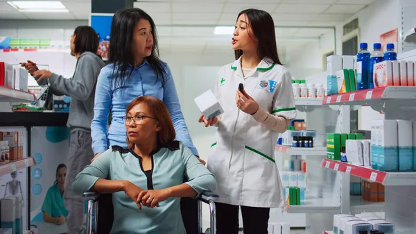 Caregiver Woman Wheelchair User Asking Pharmacist Pills Drugs Looking Prescription — Stock Photo, Image
