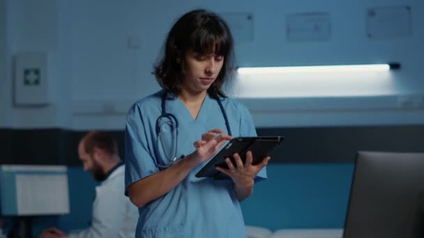认真的护士在医院办公室上夜班 同时在电脑上输入医学知识的肖像 医生助理计划药物治疗以帮助治疗病人疾病 — 图库视频影像