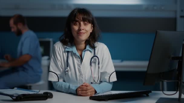 Leende Läkare Står Vid Skrivbordet Sjukhuset Kontor Arbetar Efter Timmar — Stockvideo