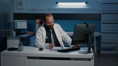 Uzman doktor video görüşme konferansı sırasında uzaktan doktorla konuşuyor. Hastanedeki sağlık hizmetleri ofisinde saatlerce çalışan hasta raporunu tartışıyorlar. İlaç servisi.