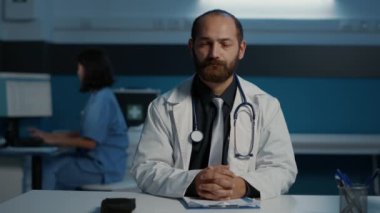 Online video görüşmesi sırasında uzaktan doktorla konuşup hasta hastalıkları uzmanlığı planlama tedavisini tartışan bir pov. Hastane ofisinde saatlerce çalışan tıbbi personel.