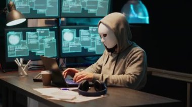 Maskeli bir hırsız veritabanı sunucusundan bilgi çalıyor, bilgisayar donanım sistemini hackliyor. Kapüşonlu ve maskeli bir bilgisayar korsanı ofiste bilişim güvenliği ihlali yaparak virüs virüsü yaratıyor..