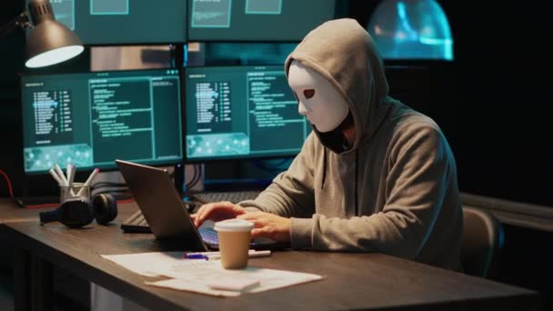 マスクハッキングデータベースサーバーを持つIt泥棒プログラマー コンピュータシステムをハッキングし マルウェアを作成するためにウイルスを活性化させるフード付きハッカー ビッグデータを盗み情報を漏洩 — ストック動画