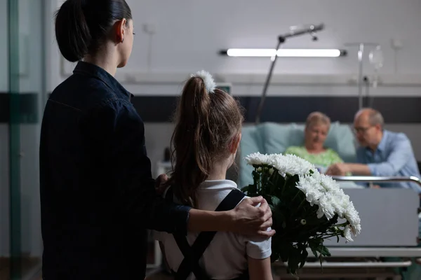 Junge Frau Bringt Kleine Tochter Ihrer Erholsamen Großmutter Ins Krankenhaus — Stockfoto