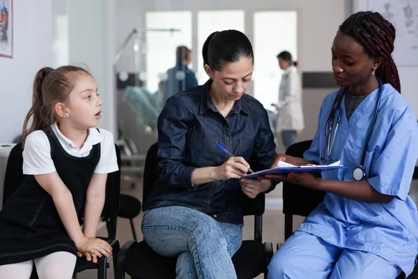 African American Doctor Filling Out Child Admission Paperwork Pediatric Hospital — Foto Stock