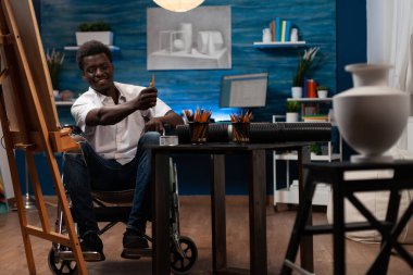 Afro-Amerikan profesyonel karikatürist vazo kullanarak başyapıt yaratıyor. Tekerlekli sandalye kullanan sanatçı çizim sürecini başlatıyor. Sanatsal yetenekleri olan, sağlık durumuyla yaşayan, çizim yapan bir adam.