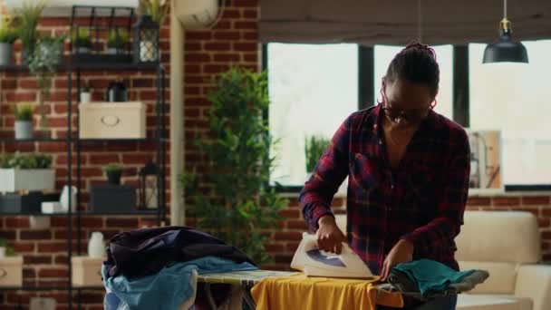 Африканська Американка Використовує Парове Залізо Прасувальну Дошку Згладжуючи Крези Одязі — стокове відео