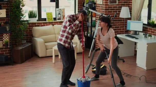 Weseli Ludzie Pokazując Ruchy Taneczne Zabawy Sprzątanie Salonu Pomocą Mopa — Wideo stockowe