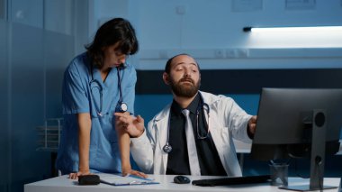 Tıp asistanı hastane muayenesi sırasında doktor tarafından uygunsuz bir şekilde dokunulurken saatlerce çalışıyor. Hemşire fiziksel tacizden muzdarip.