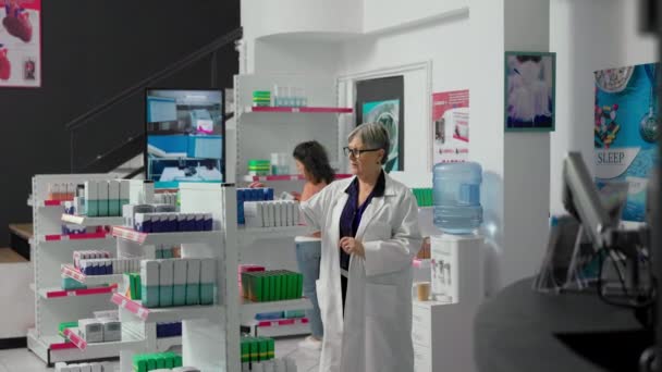 Senior Assistant Working Pharmacist Arranging Medicaments Pharmacy Shelves Checking Boxes — Stockvideo