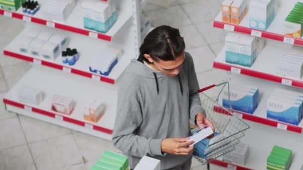 Азіатський Клієнт Дивиться Коробки Таблетками Аптеці Читає Посилку Щоб Купити — стокове відео