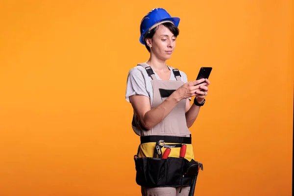 Distracted Female Builder Using Smartphone App Studio Scrolling Social Media — Stock Photo, Image