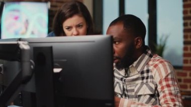 Diverse team of employees working on software development with manufacturing interface, infographics. IT engineers brainstorming ideas to develop production with artificial intelligence.