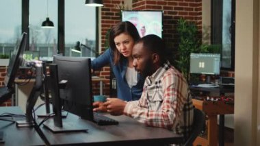 Diverse team of developers working on infographics development, analyzing 3d render software on computer. Man and woman brainstorming ideas to create artistic modern content at office.