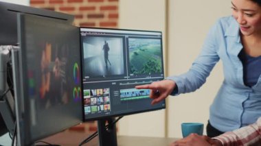 Diverse team of videographers working on movie footage edit with professional production software, creating film content. Coworkers brainstorming ideas to create video and audio montage.