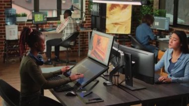 Game industry developers working on artistic development design with multiple displays on desk. Team of production department employees developing artificial intelligence technology.