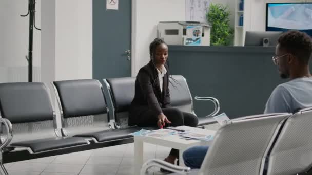 Female Nurse Consulting Young Woman Hospital Waiting Area Talking Disease — Vídeo de Stock