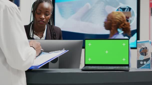 在医院大厅 人们在笔记本电脑上使用绿色显示屏 在保健中心使用检查表单文件 带有空白模型模板和前台复制空间的孤立色键显示 — 图库视频影像