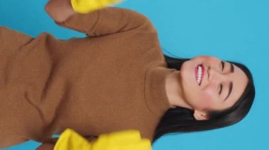 Vertical video: Happy asian maid being happy about finishing house cleaning while enjoying appreciation from her customers. Homekepper doing wonderful job, making sure every inch of the house was