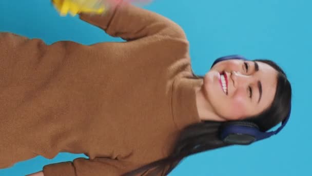 Vertical Video Cheeful Housekeeper Wearing Headphones While Dancing Having Fun — Stock Video