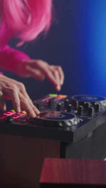 垂直ビデオ ミュージシャンはテクノとエレクトロニックサウンドを混合し ファンとパーティーを楽しみ 夜にクラブでコンサートを行うDjテーブルに立っています ピンク色の髪で音楽を演奏するアジアのアーティスト — ストック動画