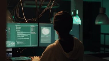 Skilled male hacker exploiting system vulnerability and breaking into firewall encryption, using hacktivism concept to steal information. Young man planting pc malware on computer server.
