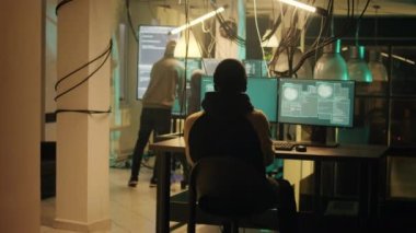 Happy thief successfully breaking network system on computer, doing hacking, cyberwarfare and espionage work at night. Criminal being congratulated about cryptojacking achievement.