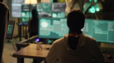 Cyber criminals using knowledge of computer systems to access sensitive information illegally, making online threats and asking ransom. Male thief hacking security network at night. Handheld shot.