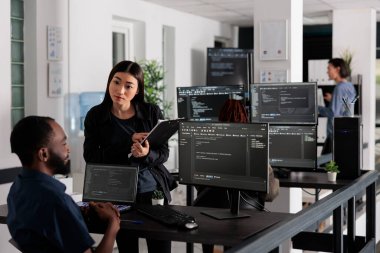 Team of system engineers working on software development with source code, looking at computer monitor. IT app developer writing ai algorithm in office, online cloud computing in agency