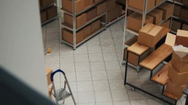 Empty storehouse space with stacks of cardboard boxes, small business concept with shelves and racks of stock merchandise. Products packed in packages used for shipment and delivery.