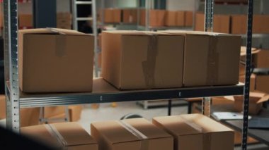 Empty storage room filled with many cardboard boxes on racks, empty warehouse with office space used to ship merchandise orders and do quality control. Storehouse with goods, logistics work.