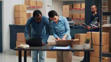 Entrepreneurs team putting goods in boxes for stock shipment and delivery, working on retail development. Partners shipping merchandise in packages from racks, logistics and quality control.