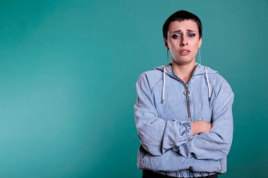 Portrait of sad unhappy woman standing with arm crossed while crying in studio with isolated background, person having negative emotion. Emotional female looking at camera with grief expression