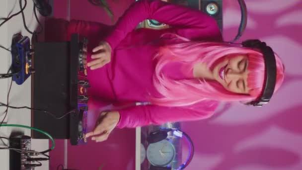 Вертикальное Видео Мбаппе Розовыми Волосами Стоит Диджейским Столом Наслаждаясь Миксом — стоковое видео