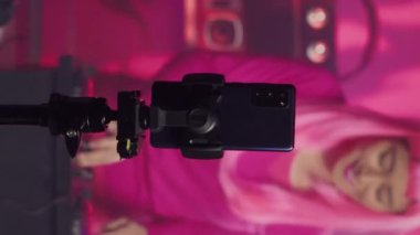 Vertical video: Musician recording music session with phone camera, mixing and mastering electronic sound preparing eletronic album. Artist performing techno song using professional audio equipment