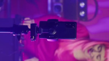Vertical video: Performer recording song process with phone camera, mixing and mastering electronic sound preparing eletronic album. Dj artist performing techno music using professional audio
