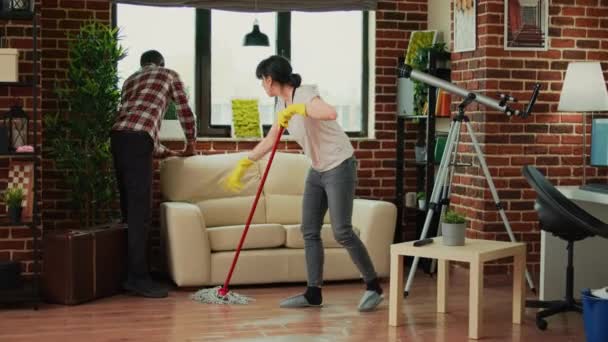 Young Couple Washing Wooden Floor Mop Husband Helping Wife Clean — Vídeo de stock